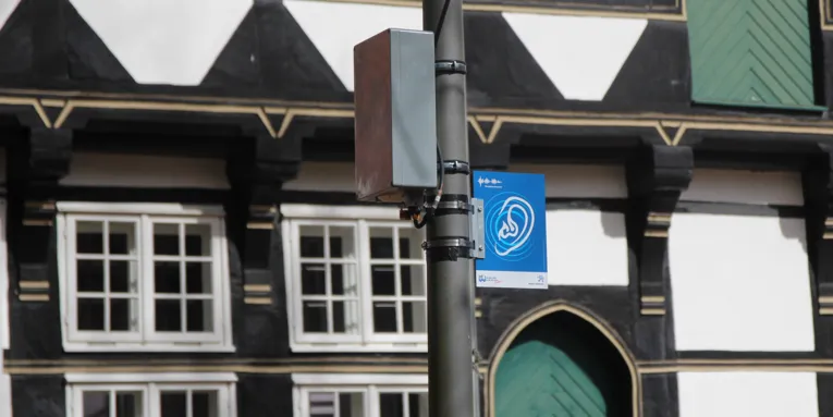 Eine Laterne mit einem Lautsprecher vor einem Fachwerkhaus